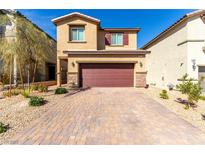 Two-story home featuring a brick driveway and a two-car garage at 10922 Cambridge Lakes Ave, Las Vegas, NV 89166