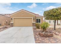 Charming single-story home with a two-car garage, desert landscaping, and a brick-paved driveway at 2404 Garganey Ave, North Las Vegas, NV 89084