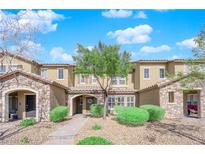 Charming townhome features a stone facade, well-manicured landscaping, and inviting walkway leading to the front door at 3064 Bicentennial Pkwy, Henderson, NV 89044