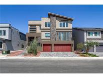 Striking three-story home with modern design elements and a red two-car garage at 7180 Grace Estate Ave, Las Vegas, NV 89113