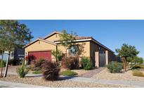 Charming single-story home with well-manicured landscaping, red garage door, and inviting curb appeal at 7910 Shimmery St, North Las Vegas, NV 89084