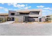 Contemporary home with a gray exterior, minimalist landscaping, and clean architectural lines at 801 Dragons Eye Dr, Henderson, NV 89012