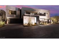 Modern home exterior with architectural design, desert landscaping, and a private two-car garage at 801 Dragons Eye Dr, Henderson, NV 89012