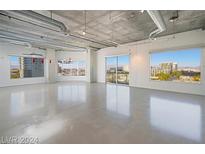 Bright, open living room features polished concrete floors and large windows with city views at 900 Las Vegas Blvd # 804, Las Vegas, NV 89101