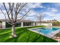 Stunning backyard features lush lawn, large pool, and covered patio perfect for outdoor entertaining at 10313 Orkiney Dr, Las Vegas, NV 89144