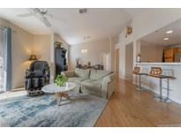 Inviting living room with open floor plan, ceiling fan, wood floors and stylish decor at 2325 Windmill Pkwy # 323, Henderson, NV 89074