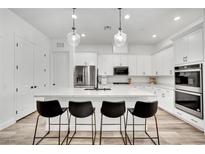 Bright kitchen features a large island with a marble countertop, pendant lighting, and stainless steel appliances at 343 American Dipper St, Las Vegas, NV 89138