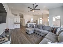 Open-concept living room with modern ceiling fan flows into kitchen and dining area at 5078 Shadow River St, Las Vegas, NV 89148