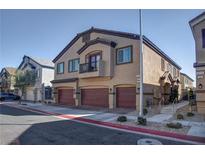 A welcoming exterior showcasing multi-Gathering units with individual garages and charming architectural details at 4705 Blaise Ave # 101, North Las Vegas, NV 89084