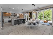Bright open kitchen featuring modern appliances, a large island with seating, and access to a covered patio at 556 Caribbean Palm Dr, Las Vegas, NV 89138