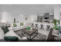 Open-concept living room and kitchen with modern finishes, stainless appliances and an inviting breakfast bar at 5729 Crenellated St # Lot 68, Las Vegas, NV 89148