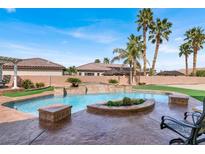 Inviting pool featuring a stone waterfall, lush landscaping, and a surrounding patio perfect for outdoor relaxation at 6392 Ebony Legends Ave, Las Vegas, NV 89131
