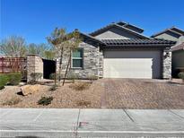Charming single-story home featuring stone accents, a brick driveway, and a two-car garage at 7082 Sayonara Vista St, North Las Vegas, NV 89084