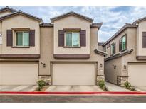 Newer construction townhome featuring a two-car garage and desert landscaping at 7232 N Decatur Blvd # 4, Las Vegas, NV 89131