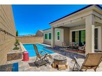 Inviting backyard with a sparkling pool, patio seating, and stylish outdoor decor, perfect for relaxation at 8525 Stokestone St, Las Vegas, NV 89166