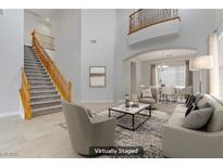 Bright living room featuring a staircase and an open floor plan with modern furnishings at 3504 Frigatebird Ln, North Las Vegas, NV 89084
