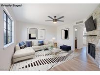 Bright living room featuring a modern ceiling fan and a stylish accent wall with a fireplace at 7086 Burcot Ave # A1, Las Vegas, NV 89156