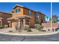 Inviting two-story home featuring stone accents, desert landscaping, and a charming covered entrance at 7440 Cobbhan Dr, Las Vegas, NV 89179