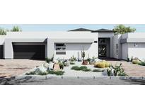 Stylish modern home featuring desert landscaping, a brick driveway, and a sleek, attached two-car garage at 8825-1 S Monte Cristo Way, Las Vegas, NV 89113
