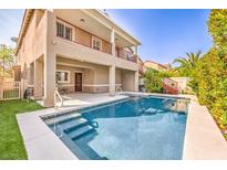 Backyard swimming pool with patio, stairs and partial view of the tan two-story home at 1332 Cedar Berry Ct, Henderson, NV 89012
