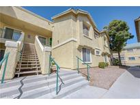 Inviting exterior view of a condo building with tan stucco, green railings, and well-maintained landscaping at 1509 Linnbaker Ln # 203, Las Vegas, NV 89110