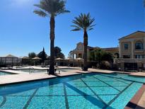 Resort-style pool area featuring multiple pools, lounging areas, and palm trees against a bright blue sky at 21 Via Visione # 201, Henderson, NV 89011