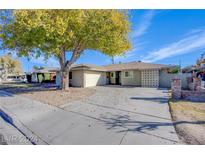 Charming single-story home with mature trees, a spacious driveway, and a well-kept front yard at 26 Jade Circle Cir, Las Vegas, NV 89106