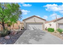 Charming single-story home featuring a well-maintained front yard with low-maintenance landscaping and attached two-car garage at 7633 Lily Trotter St, North Las Vegas, NV 89084