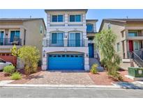 Charming three-story home featuring a blue garage door, balcony and landscaped front yard at 7665 Sandhaven St, Las Vegas, NV 89139