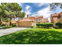Beautiful two-story home with a terracotta roof, lush lawn, and mature trees at 7999 Pinnacle Peak Ave, Las Vegas, NV 89113
