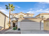 Inviting two-story home featuring a two-car garage, desert landscaping, and a mature palm tree at 9972 Trailing Vine St, Las Vegas, NV 89183