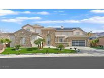 Stunning two-story home with stone accents, lush landscaping, and a three-car garage at 1320 Enchanted River Dr, Henderson, NV 89012