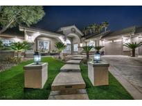 Stunning front exterior with lush landscaping, a concrete walkway, and a 3-car garage at 177 Knollwood Ct, Henderson, NV 89074