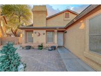 Charming single-story home with a welcoming facade, desert landscaping, and a unique brick driveway at 4055 Planetary Ln, Las Vegas, NV 89115