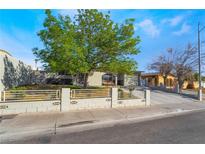 Charming single-story home featuring a well-manicured lawn and a quaint fence, complemented by a lush tree at 4258 E Twain Ave, Las Vegas, NV 89121