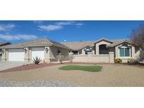 Charming single-story home featuring stucco siding, a well-manicured yard, and a two-car garage at 5090 Balhurst Ct, Pahrump, NV 89061