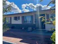 Charming single-story home with a brick accent and secure iron door at 5201 Glen Eagles Ln, Las Vegas, NV 89108