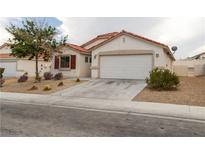 Charming single-story home featuring a red tile roof, neutral stucco, and a two-car garage at 629 Bright Lights Ave, North Las Vegas, NV 89031