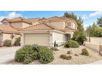 Charming two-story home with a tile roof, two-car garage, and beautifully landscaped front yard featuring desert plants and rocks at 1216 Maserati Dr, Las Vegas, NV 89117