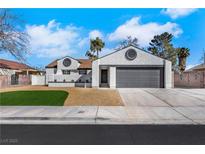 Charming one-story home featuring a gray garage door, white exterior, and well-maintained yard at 1905 Joella St, Las Vegas, NV 89108