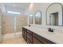 Modern bathroom featuring a double vanity, sleek fixtures, and a glass-enclosed shower at 5606 Spring Trellis St, Las Vegas, NV 89113