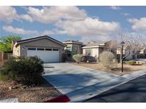 Charming single-story home featuring a two-car garage and low maintenance desert landscaping in the front yard at 8213 Cabin Springs Ave, Las Vegas, NV 89131