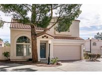 Charming townhome with tile roof, blue door, and two-car garage provides great curb appeal at 8872 Hampton Green Ave, Las Vegas, NV 89129