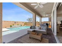 Relaxing covered patio seating area with an outdoor kitchen and a refreshing pool at 10052 Silver Comet Ct, Las Vegas, NV 89178