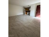 Open-concept living room featuring light, wood-look tile flooring and a view into the kitchen at 2080 Karen Ave # 15, Las Vegas, NV 89169