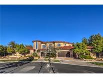 Elegant two-story home featuring a stone facade, arched windows, tile roof, and lush landscaping at 6 Fire Rock Ct, Las Vegas, NV 89141