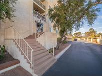 A condominium building with a staircase leading to the entrance and well-manicured landscaping at 725 N Royal Crest Cir # 213, Las Vegas, NV 89169