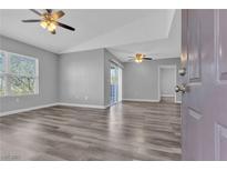 Spacious living room featuring modern gray walls, updated ceiling fans, and stylish wood-look flooring at 7255 W Sunset Rd # 2007, Las Vegas, NV 89113