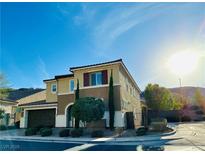 Beautiful two-story stucco home with a well-manicured lawn, dark shutters, and a two-car garage at 945 Pomander Point Pl, Henderson, NV 89012