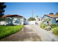 Single-story homes featuring a long driveway and manicured lawn in a residential neighborhood at 1254 Melville Dr, Las Vegas, NV 89102